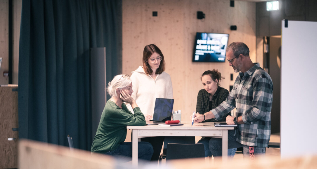 Learning Lunch - KI als Gamechanger Vier Personen an einem Besprechungstisch