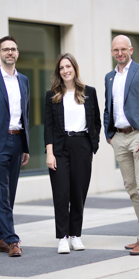 Drei Personen der Geschäftsstelle GRdigital stehen nebeneinander vor der BGS: Daniel Fuchs, Flurina Jäger und Marcel Meyer.